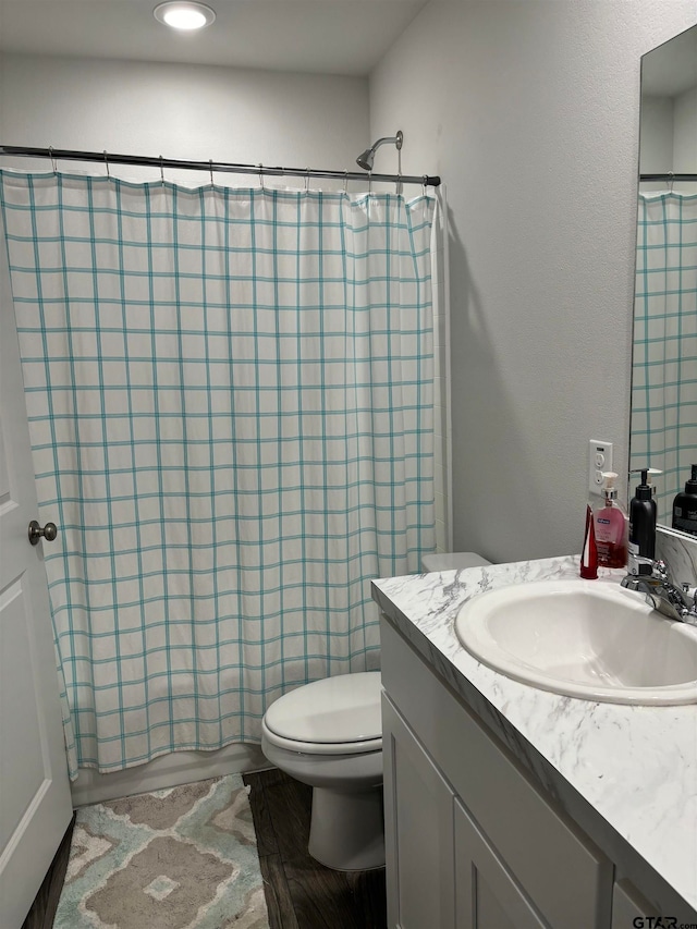 full bathroom with wood-type flooring, vanity, toilet, and shower / tub combo with curtain