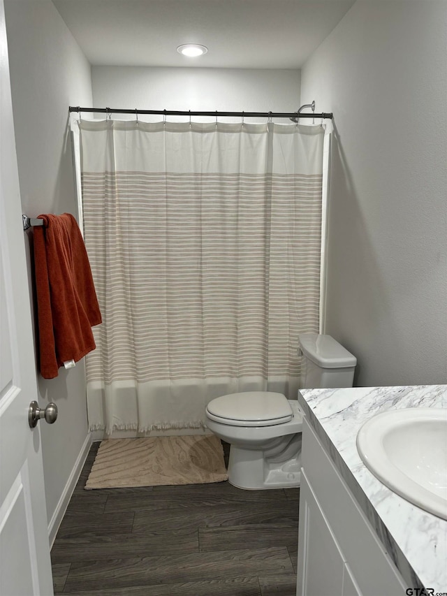 full bathroom featuring vanity, toilet, wood-type flooring, and shower / tub combo with curtain