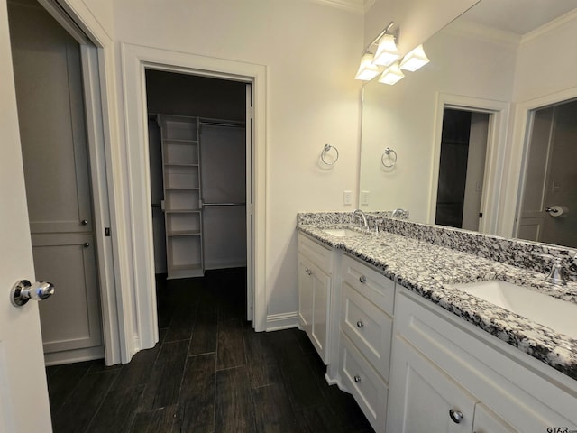 823 Lindsey Ln, Whitehouse, TX 75791 - bathroom featuring crown molding, double vanity, a spacious closet, and wood finished floors