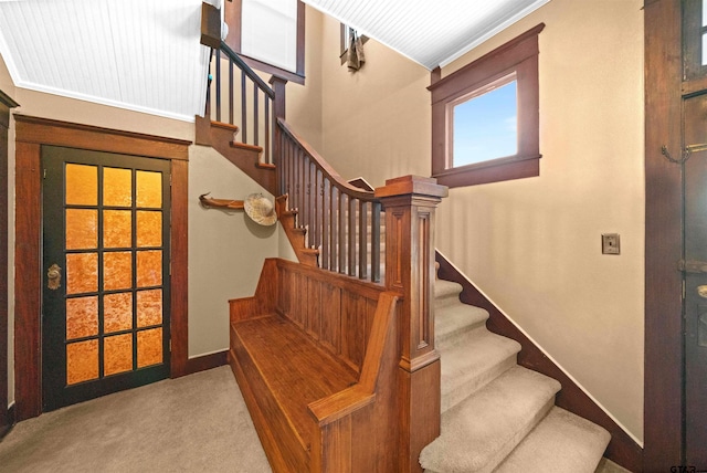 staircase featuring carpet floors and baseboards