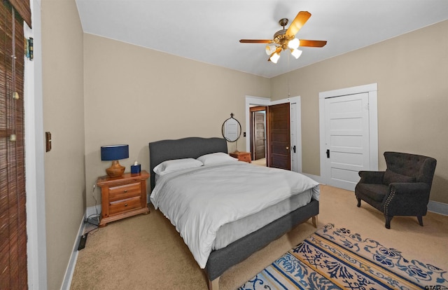 bedroom featuring baseboards, a ceiling fan, and light colored carpet