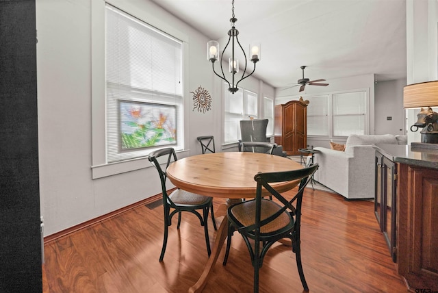 dining space with baseboards, ceiling fan, and dark wood-type flooring