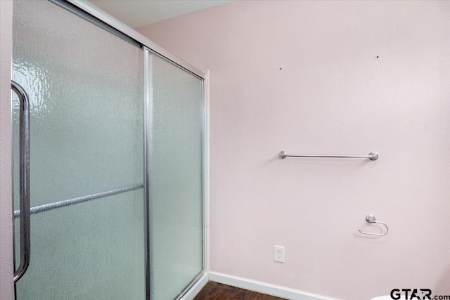 bathroom with hardwood / wood-style flooring and walk in shower