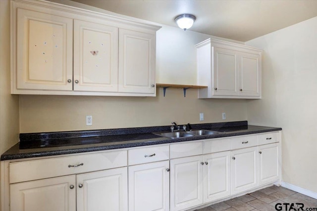 kitchen featuring sink, white cabinets, and light wood-type flooring