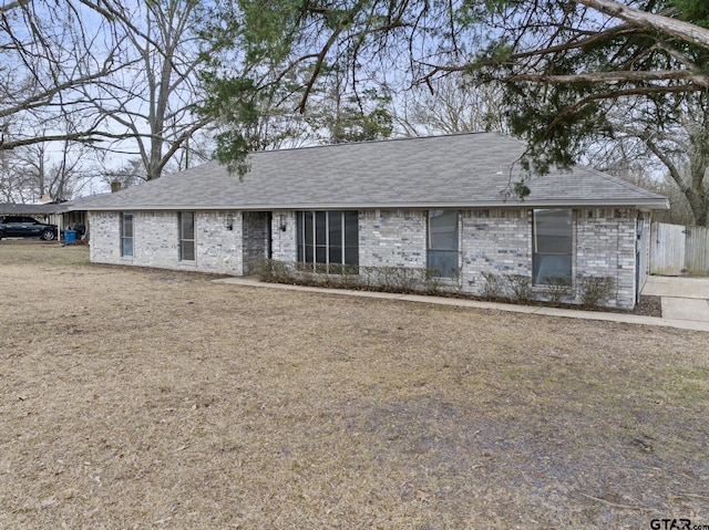 ranch-style house with a shingled roof and brick siding