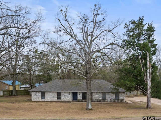 view of front facade with fence and roof with shingles