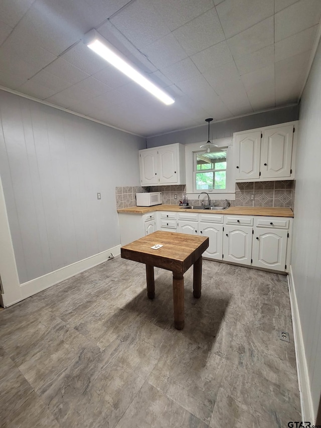 kitchen featuring white cabinetry, sink, and backsplash