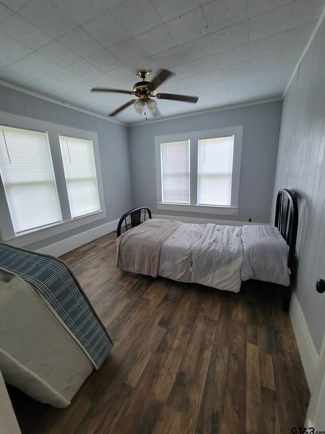 bedroom with ceiling fan, multiple windows, and dark hardwood / wood-style floors