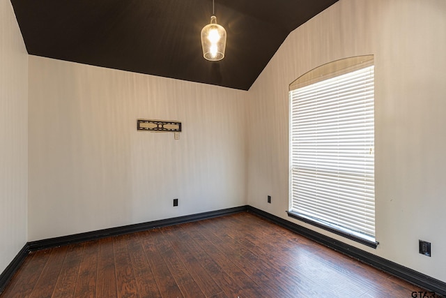 spare room featuring lofted ceiling and dark hardwood / wood-style flooring