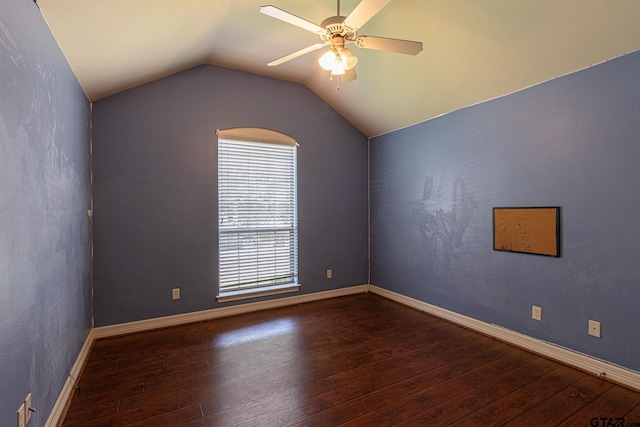 empty room with ceiling fan, dark hardwood / wood-style floors, and vaulted ceiling