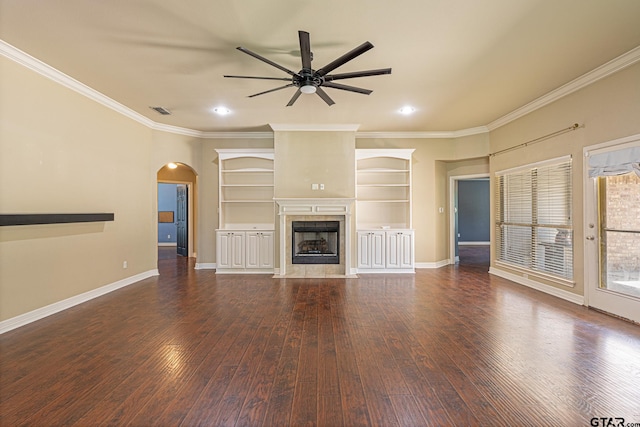 unfurnished living room with ornamental molding, dark wood-type flooring, a tile fireplace, and ceiling fan