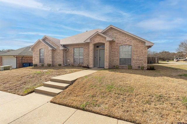 ranch-style house featuring central air condition unit and a front lawn