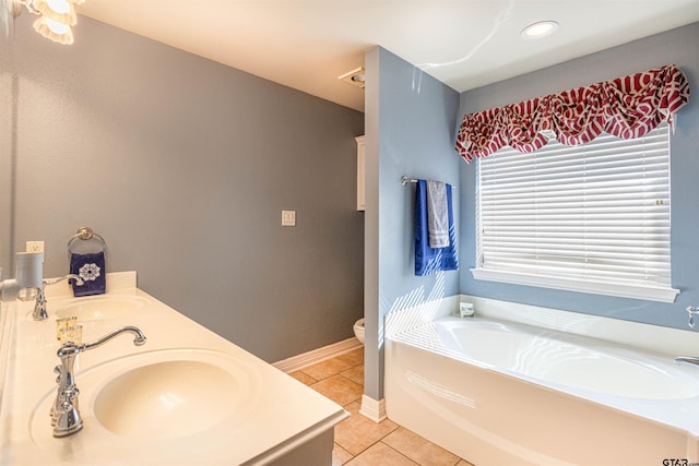 bathroom featuring tile patterned floors, toilet, vanity, and a washtub