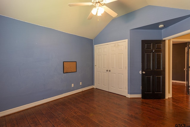 unfurnished bedroom featuring ceiling fan, lofted ceiling, dark hardwood / wood-style flooring, and a closet