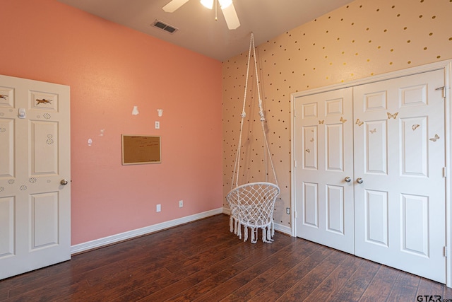 unfurnished bedroom featuring dark hardwood / wood-style floors, ceiling fan, and a closet