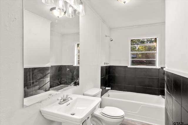 full bathroom with tiled shower / bath, sink, wood-type flooring, toilet, and tile walls