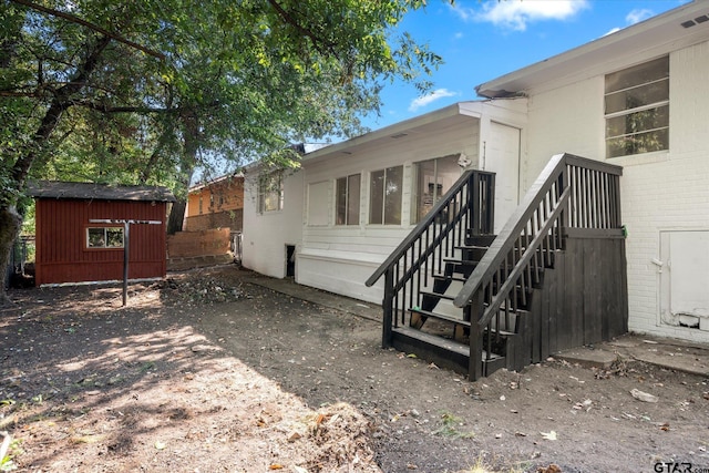 view of side of home with a storage shed