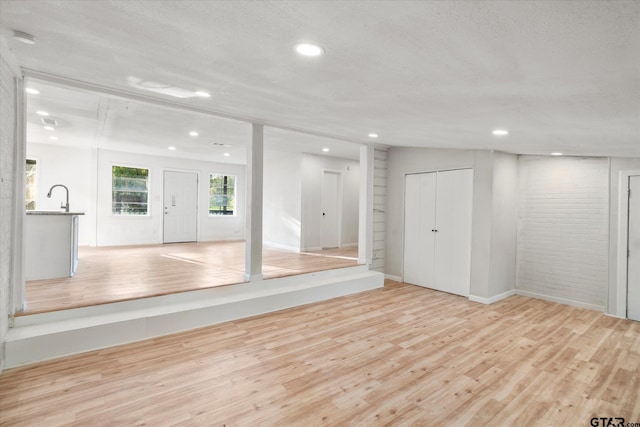 interior space featuring light hardwood / wood-style floors, a textured ceiling, and sink