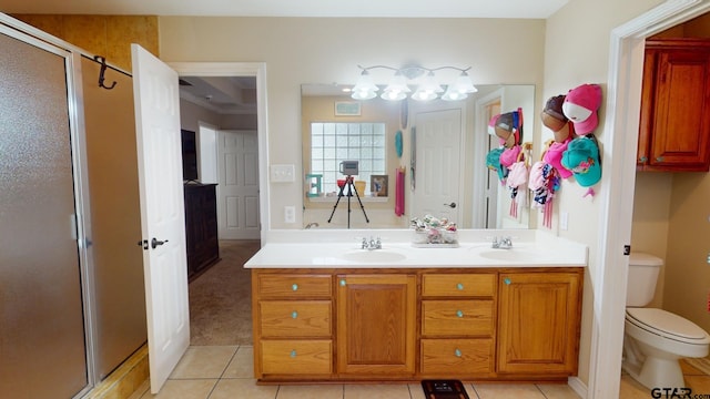 bathroom featuring vanity, a shower with shower door, tile patterned flooring, and toilet