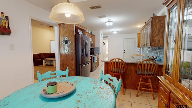 dining space with sink, ceiling fan, and light tile patterned floors