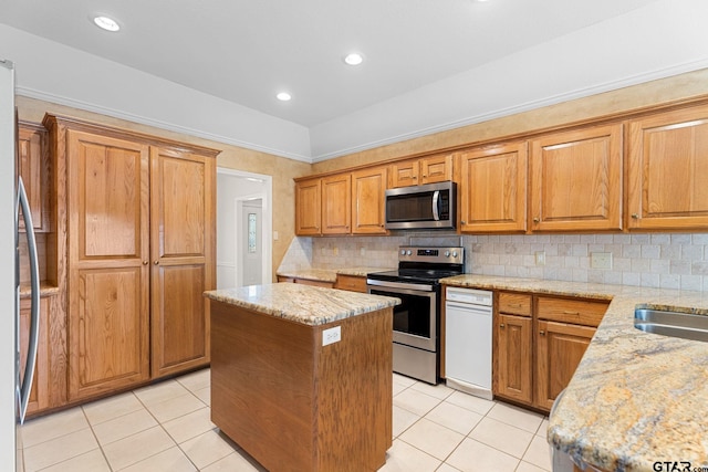 kitchen featuring a center island, stainless steel appliances, decorative backsplash, and light tile patterned flooring