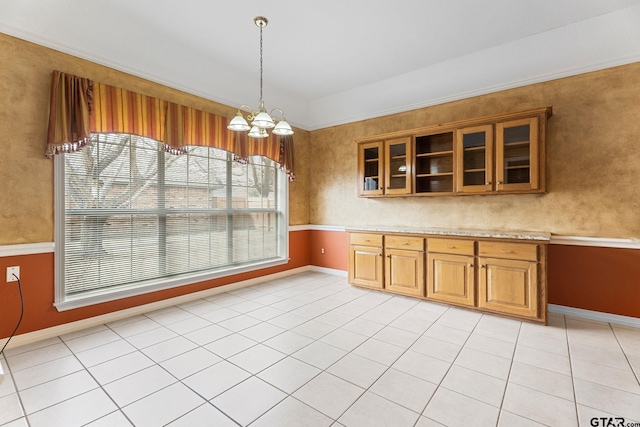 unfurnished dining area featuring light tile patterned floors, baseboards, and an inviting chandelier