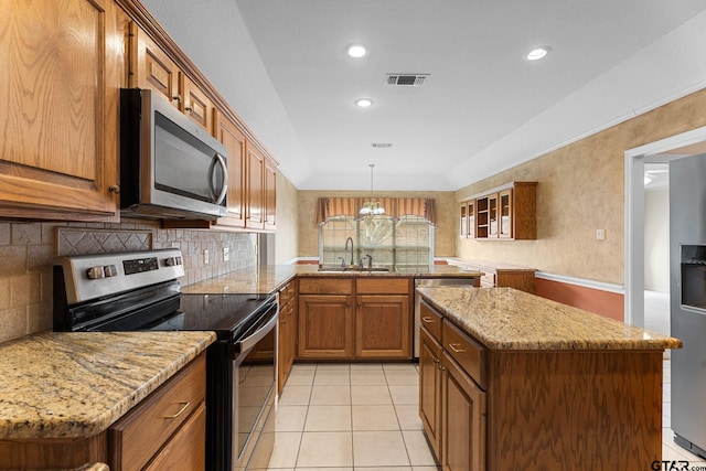 kitchen with visible vents, brown cabinets, a peninsula, stainless steel appliances, and a sink