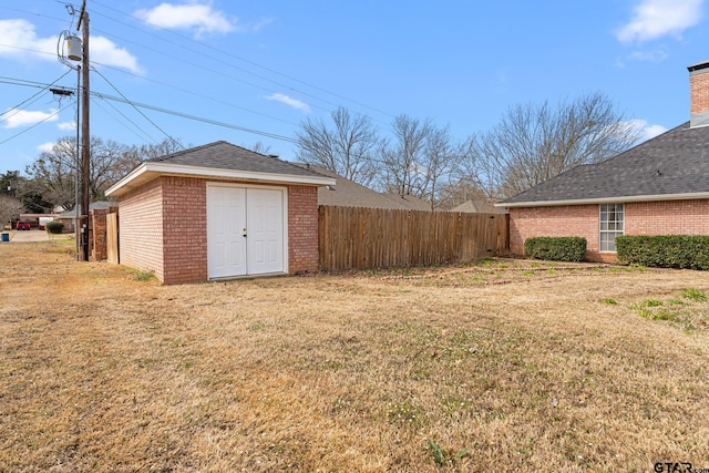 view of yard with a storage shed, fence, and an outdoor structure