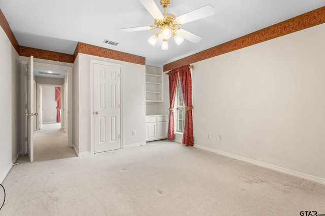 unfurnished bedroom with a ceiling fan, carpet flooring, visible vents, and baseboards