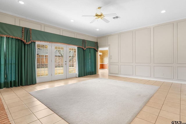 interior space with a ceiling fan, visible vents, and a decorative wall