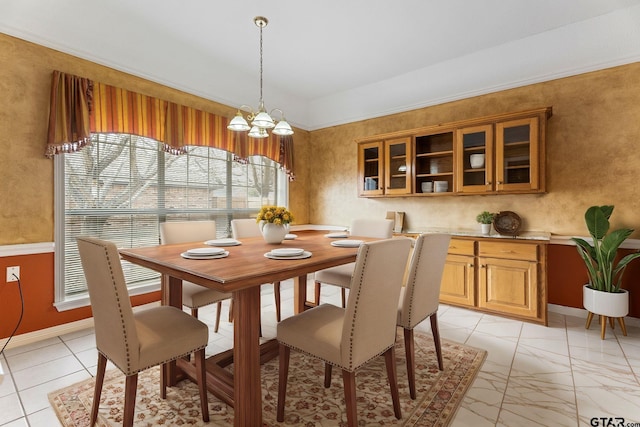 dining area featuring marble finish floor, a notable chandelier, and baseboards