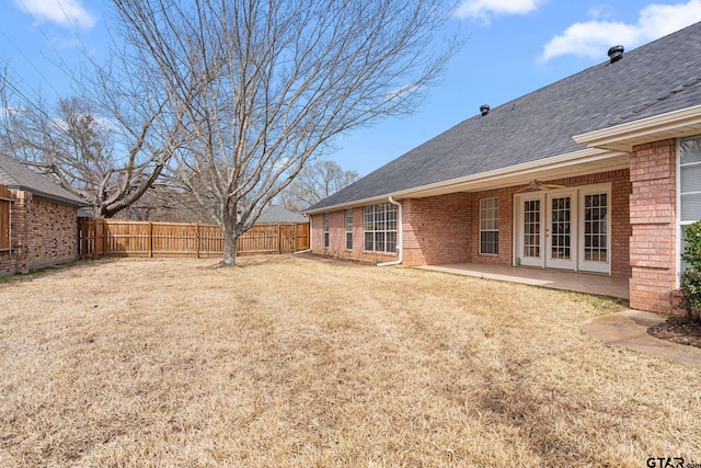 view of yard with a fenced backyard, a patio, a ceiling fan, and french doors