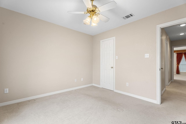 empty room with ceiling fan, visible vents, baseboards, and light colored carpet