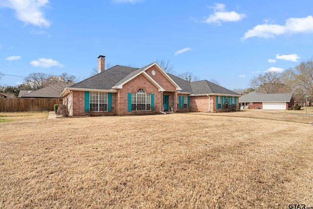 single story home featuring brick siding, roof with shingles, a chimney, a front yard, and fence