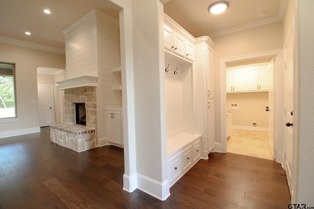 mudroom featuring a stone fireplace, ornamental molding, and dark hardwood / wood-style floors