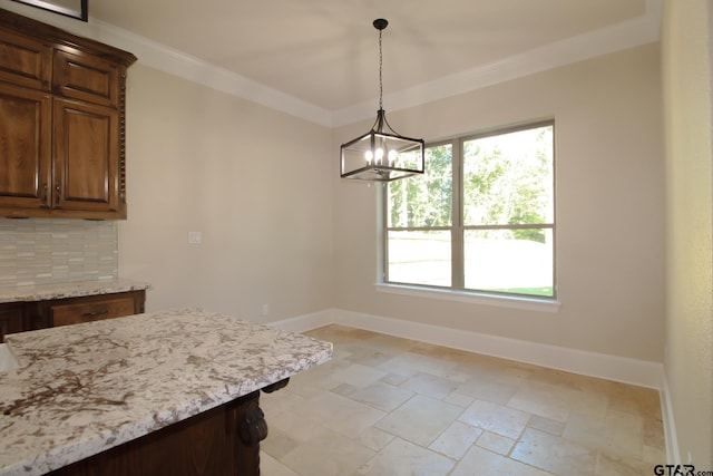 unfurnished dining area featuring an inviting chandelier and crown molding