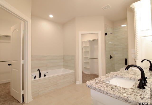 bathroom featuring independent shower and bath, tile patterned flooring, and vanity