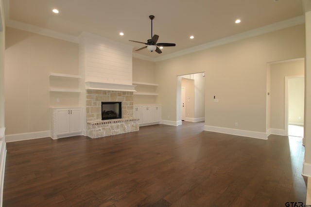 unfurnished living room featuring dark wood-type flooring, a fireplace, ceiling fan, and ornamental molding