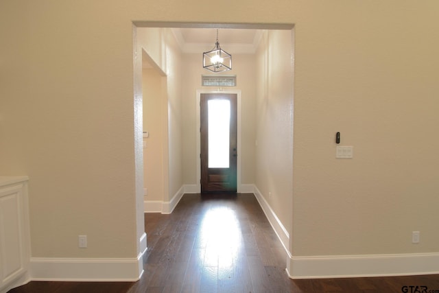 foyer with dark hardwood / wood-style flooring, a chandelier, and crown molding