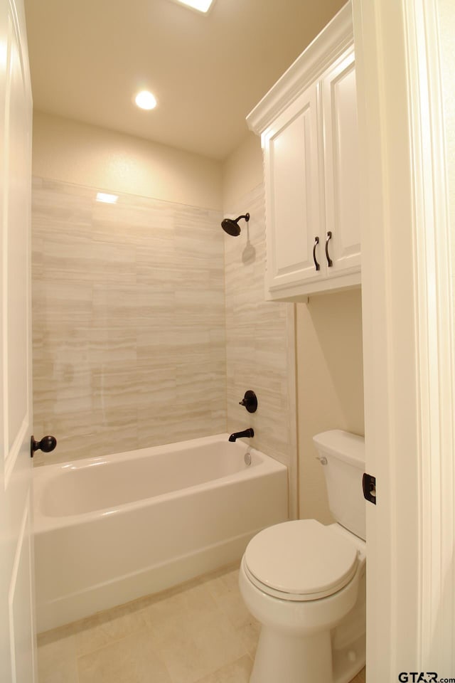 bathroom with tile patterned flooring, toilet, and tiled shower / bath combo