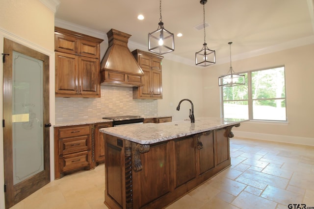 kitchen with tasteful backsplash, custom exhaust hood, stainless steel range oven, an island with sink, and hanging light fixtures