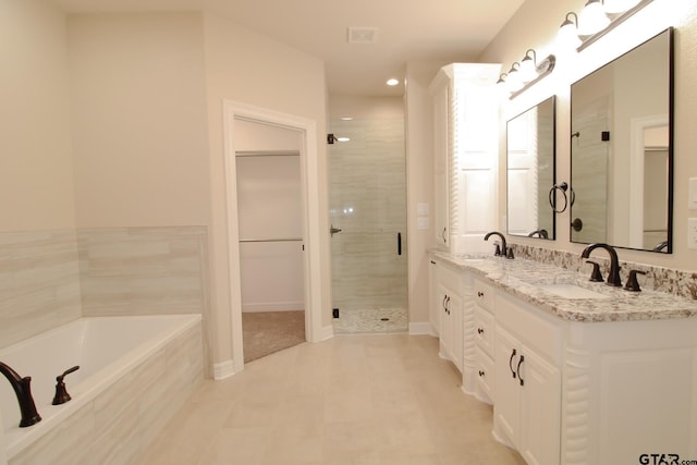 bathroom with vanity and shower with separate bathtub