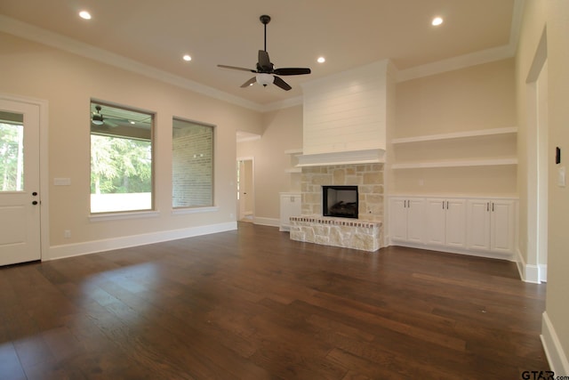 unfurnished living room featuring dark wood-type flooring, a fireplace, ceiling fan, and crown molding