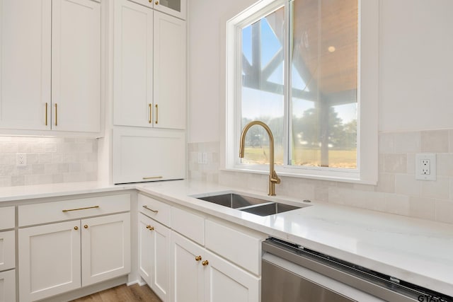 kitchen with white cabinetry, sink, backsplash, and dishwasher