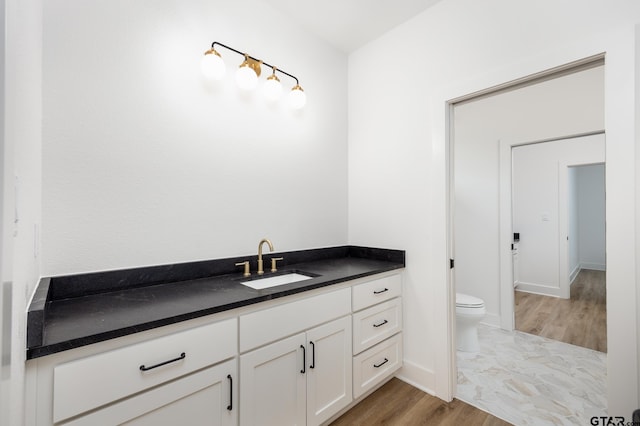 bathroom with wood-type flooring, toilet, and vanity