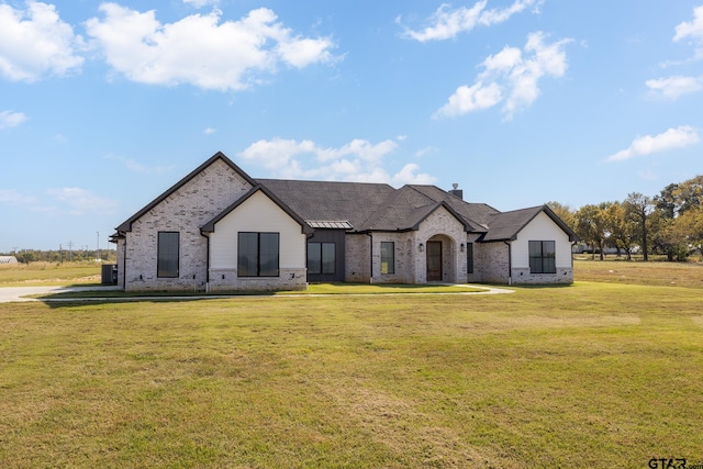 french country inspired facade with a front lawn