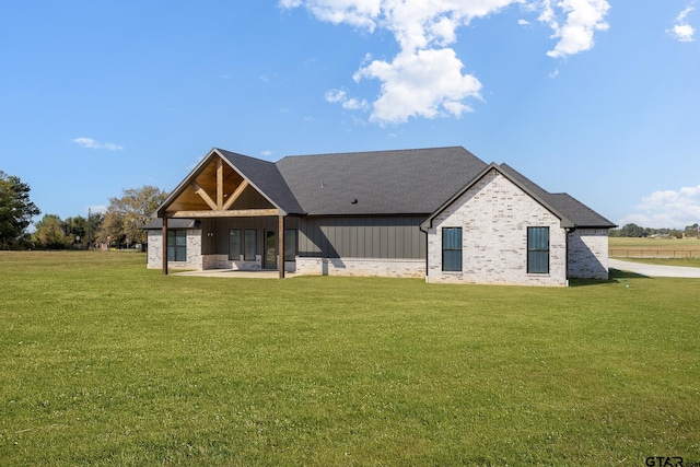 rear view of house featuring a patio area and a yard