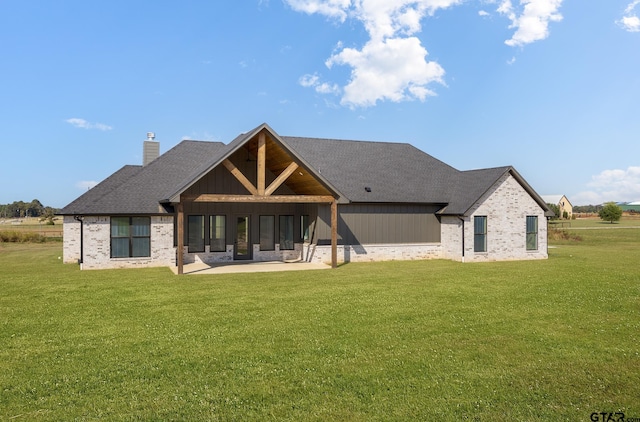 rear view of property with a lawn and a patio area