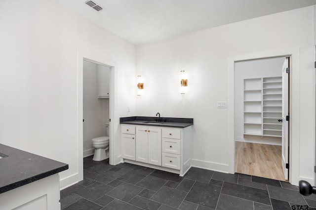 bathroom with toilet, vanity, and hardwood / wood-style floors