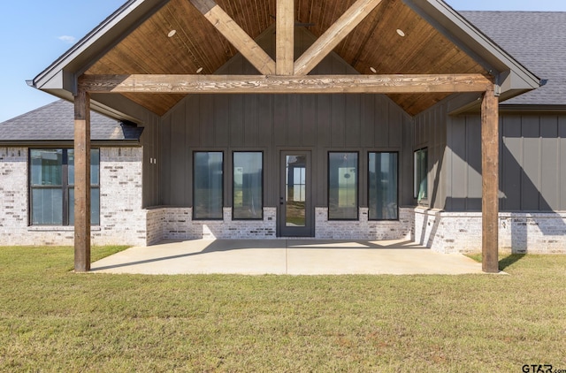 rear view of property featuring a yard and a patio area